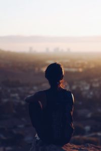 silhouette of woman looking out over los angeles during sunset